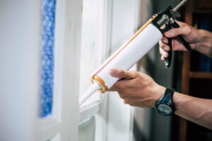 The carpenter holds the glue and attaches to the window.
