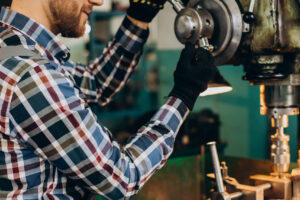 Workman wearing hard hat working with metal constructions at factory